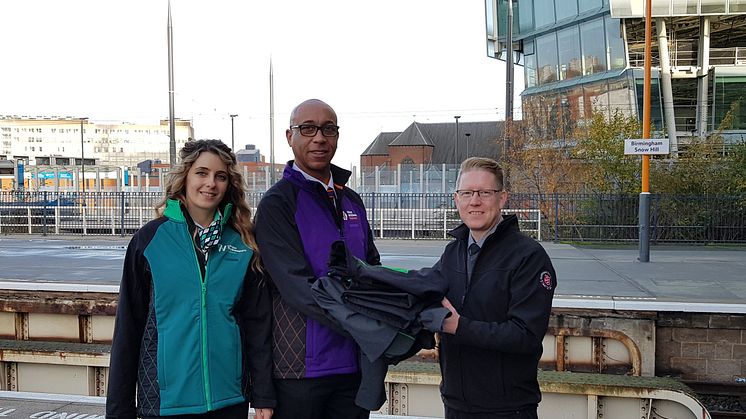  A London Northwestern Railway revenue protection officer and West Midlands Railway driver handing over old uniforms to Justin Frost from The Salvation Army Trading Company at Birmingham Snow Hill station