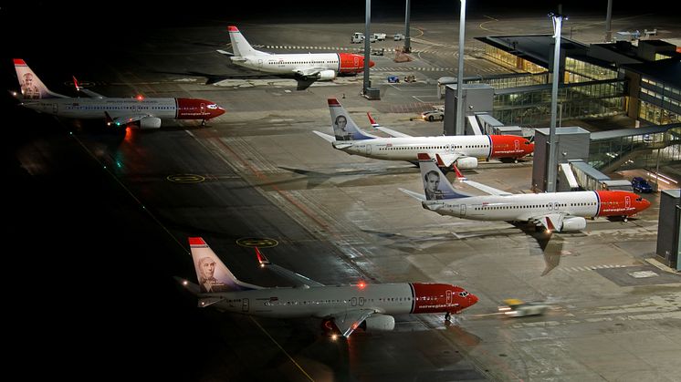 Several Norwegian aircraft parked at Oslo Airport Gardermoen at night