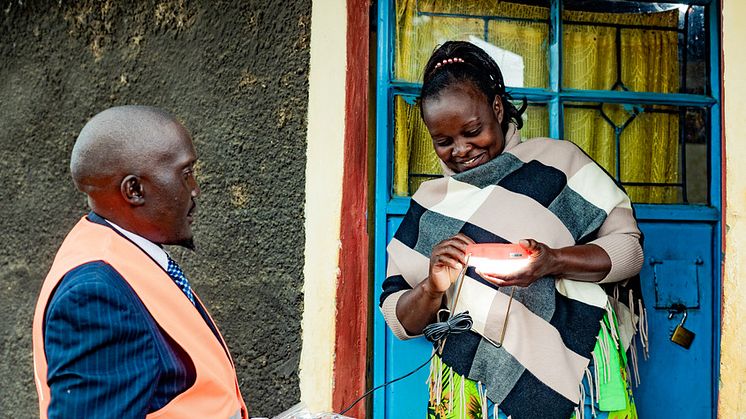 Erastus Ndaka från d.light levererar en solcellslampa till Redempta Nduva i Machakos, Kenya