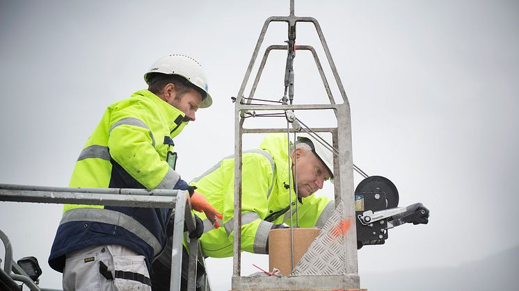 Murmester Thomas Djønne og Sturle Stenhjem, den lokale Leca-representanten, firer ned et keramisk innerrør på Jernbanepersonalets borettslag i Bergen. 