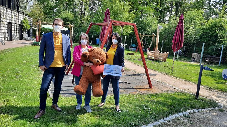 Alexander Schröder, Kerstin Stadler und Katja Hellinger präsentieren den Spendenschek im Garten des Kinderhospizes