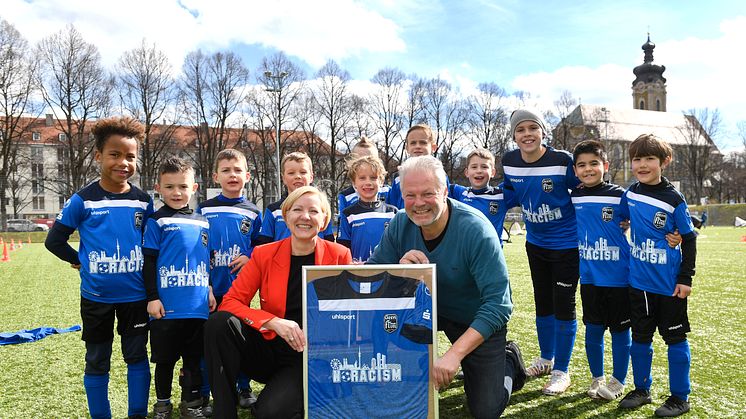 Sabine Schölzel (Vorständin Stadtsparkasse München), Michael Franke (1. Vorsitzender FT Gern) und die U7-Fußballmannschaft der FT Gern freuen sich über die neuen Trikots.