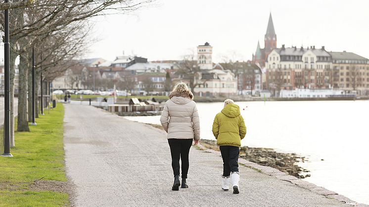 Bilden visar två kvinnor på rask promenad i staden. 