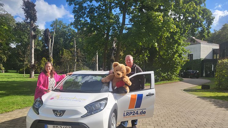 Ulrike Herkner und Michael Meinel präsentieren stolz das neue Auto vor dem Kinderhospiz Bärenherz
