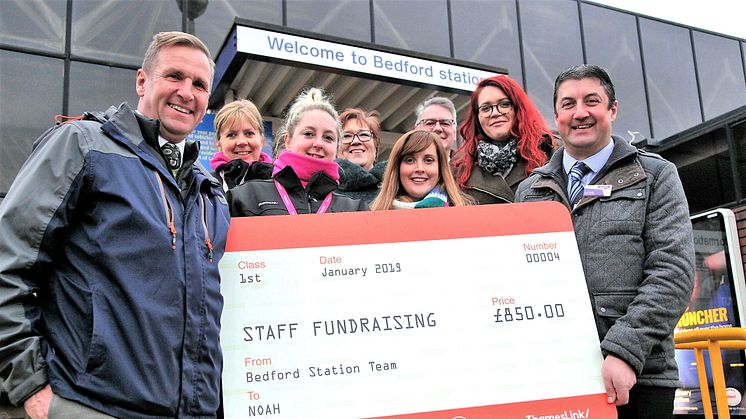 Jim O'Connor MBE, NOAH Enterprise Chief Executive (left) accepts the £850 donation from Bedford Station Manager Joe Healy (right) and the Thameslink bake sale team