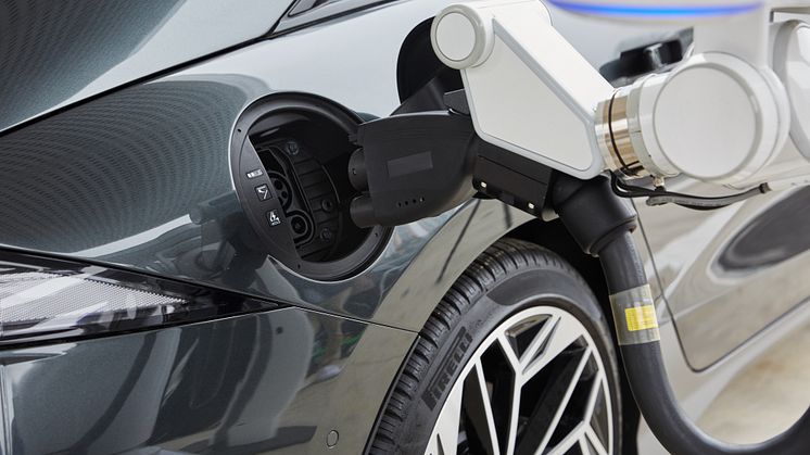 Den automatiske opladningsrobot (ACR) kommunikerer med det elektriske køretøj (EV) og åbner automatisk ladeporten og tilslutter