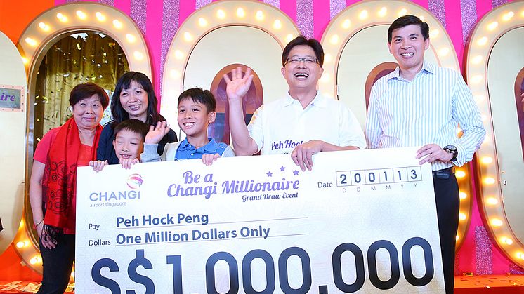 Mr Peh and his family receiving the S$1 million cheque from Mr Lee Seow Hiang, CEO of Changi Airport Group