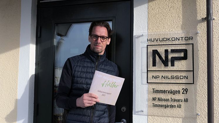 Hållbarhetschef Henrik Olandersson "håller" upp rapporten i tryckt form.