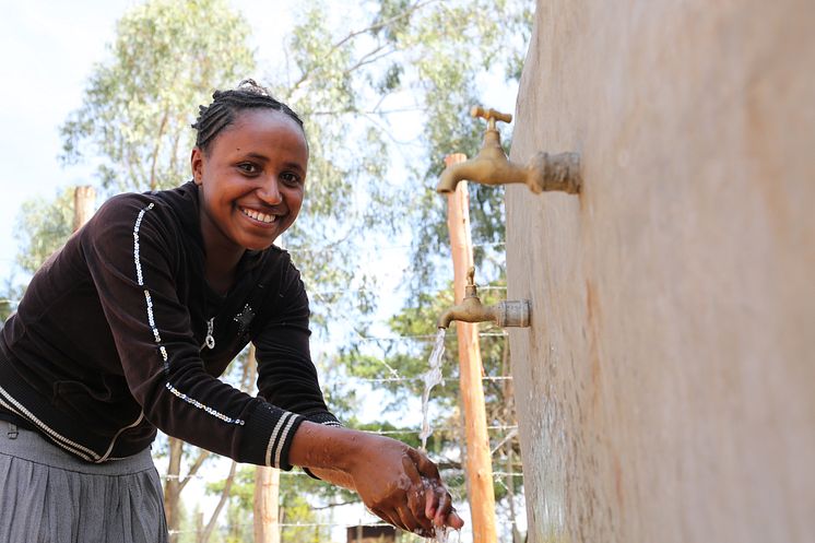 14-åriga Mitikie från Etiopien njuter av rent vatten