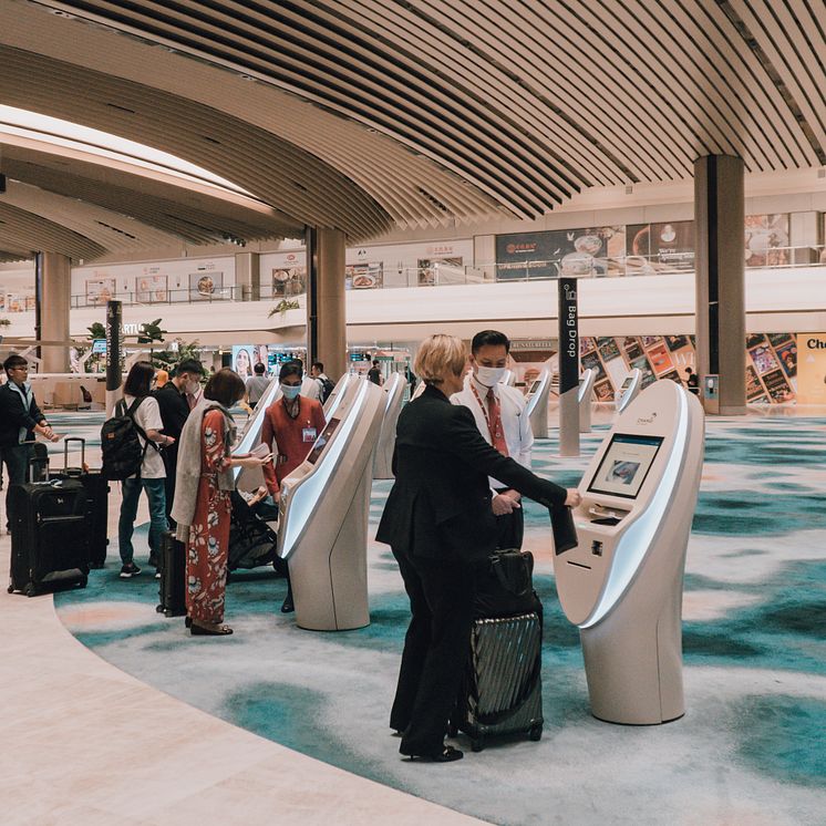 1. SIA passengers checking in for their flight at the automated check-in kiosks.