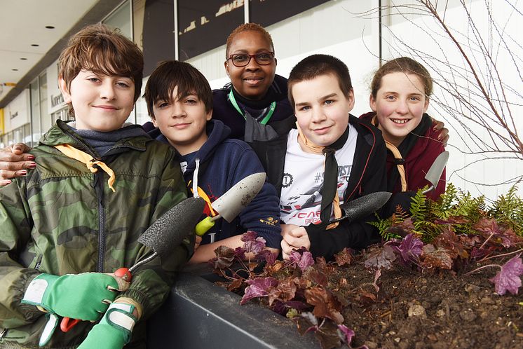 Great Linford Scout and railway staff fill new planters at Milton Keynes station