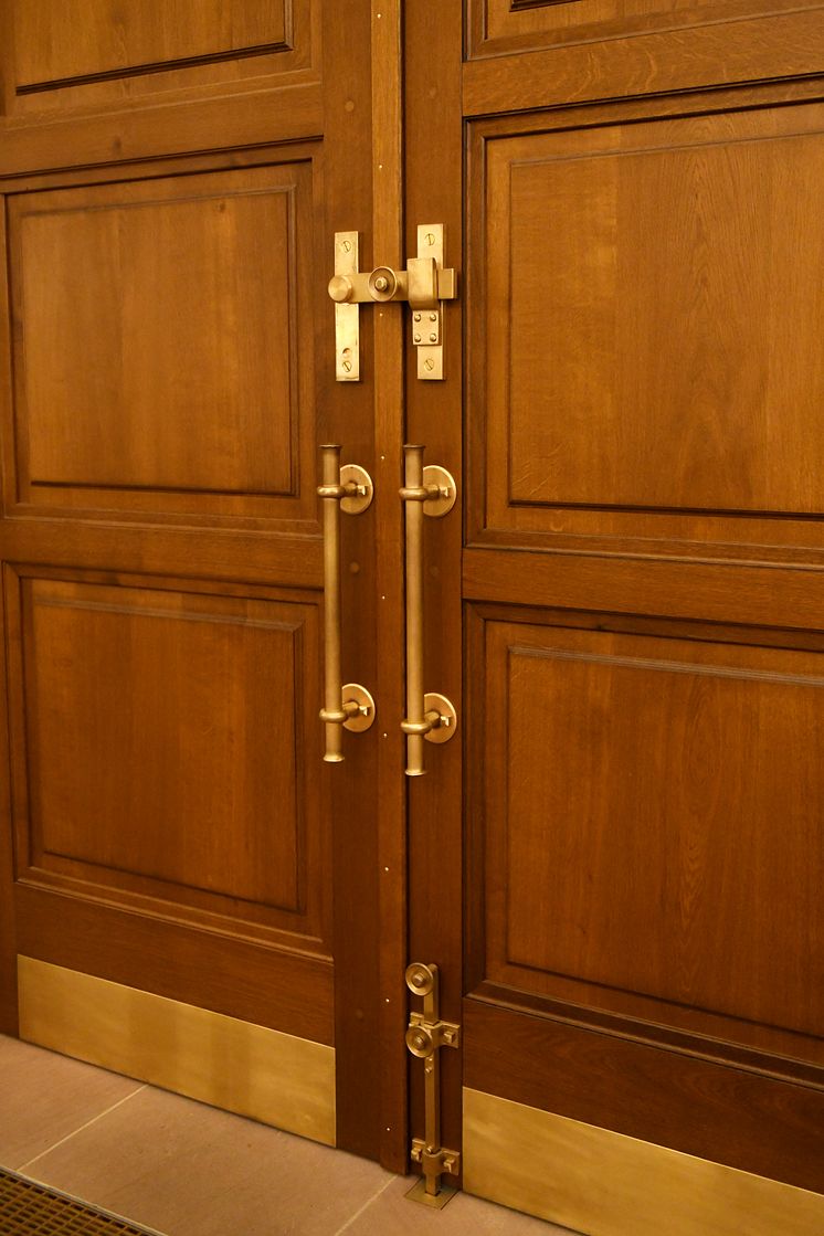 Kategorie Metallgestaltung: Die Türbeschläge des Eingangsportals sind so gestaltet, dass sie sich harmonisch ins Gesamtbild einfügen. 